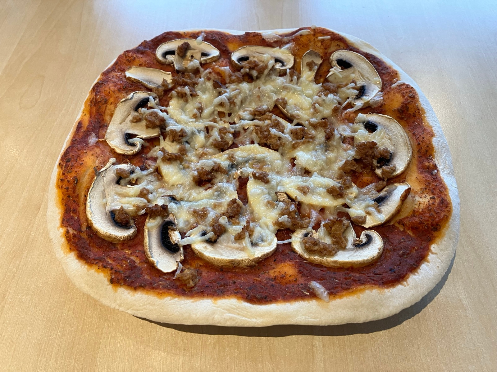 Fertige Pizza auf einem Pizzastein gebacken